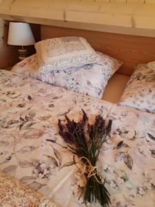 uma cama com um ramo de flores em Domek Lawendowe Wzgórze em Mielenko