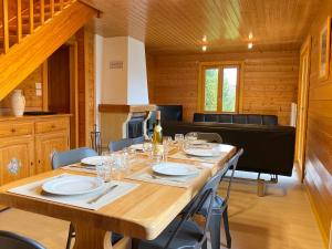 een eetkamer met een tafel met wijnglazen erop bij Chalet Sapin in Gérardmer