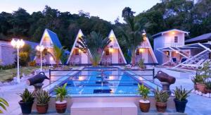 a hotel with a swimming pool in front of a house at Nipah Guesthouse Pangkor in Pangkor