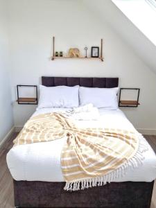 een slaapkamer met een groot bed met een deken erop bij 3 bedroom apartment near Birmingham airport/NEC in Birmingham
