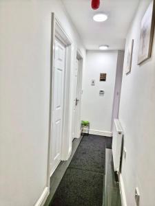 een hal met een witte deur en een zwart tapijt bij 3 bedroom apartment near Birmingham airport/NEC in Birmingham