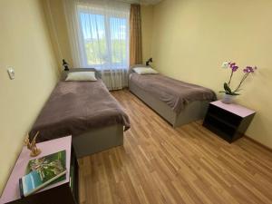 a room with two beds and a vase of flowers at Комплекс центр развития туризма in Zlatoust