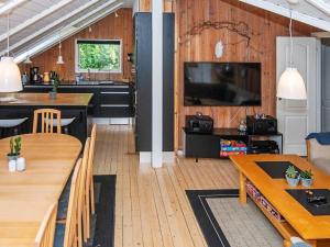 a living room with a kitchen and a dining room at Holiday Home Pøt Strandby IX in Sønderby