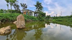 una casa sentada a orillas de un río en Bavi Annam Garden, en Ba Vì