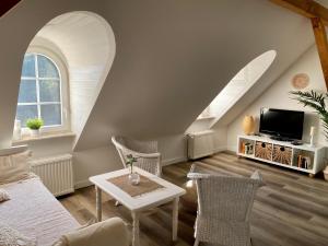 a living room with a table and chairs and a tv at Ostseeresidenz Apartments in Rerik