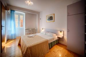 a bedroom with a bed and a table in it at Komiza Provita Guesthouse in Komiža