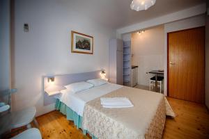 a bedroom with a large bed with a white blanket at Komiza Provita Guesthouse in Komiža
