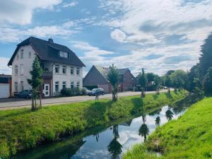 a river in a town with houses and a street at FeWo Casa in Boizenburg