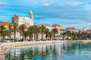 a view of a city with palm trees and buildings at Old Spalatrum Luxury Rooms in Split