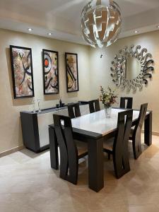 una sala da pranzo con tavolo, sedie e specchio di Appartement de luxe a Casablanca