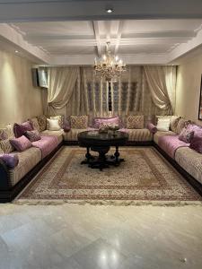 soggiorno con divani, tavolo e lampadario pendente di Appartement de luxe a Casablanca