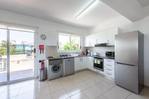 a kitchen with a refrigerator and a dishwasher at Villa Cassia by Ezoria Villas in Coral Bay