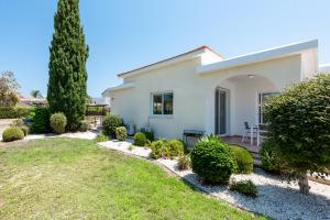 a white house with a yard and a table at Villa Cassia by Ezoria Villas in Coral Bay