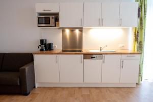uma cozinha com armários brancos e um lavatório em Apart welcom em Ischgl