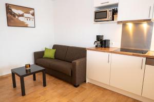 a living room with a couch and a kitchen at Apart welcom in Ischgl