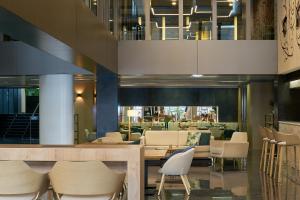 a restaurant with chairs and tables in a building at Vincci Zaragoza Zentro in Zaragoza