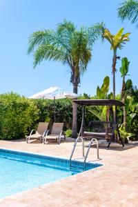 a swimming pool with two chairs and an umbrella at Villa Cassia by Ezoria Villas in Coral Bay