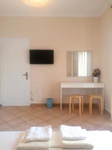 a living room with two stools and a tv on the wall at Beach Studio apartment 3, Komi in Chios