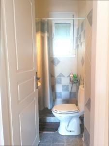 a bathroom with a toilet and a window at Beach Studio apartment 3, Komi in Chios