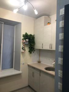 a kitchen with white cabinets and a sink at Devolano 1 in Odesa
