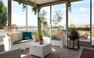 un soggiorno con mobili bianchi e ampie finestre di Family Dream Penthouse a Rimini