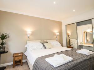 a bedroom with a large white bed and a mirror at Culreach Lodge in Grantown on Spey