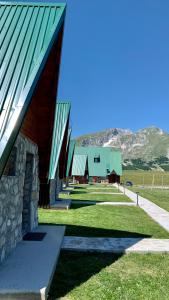 a barn with a green roof and a building at B&B Izvor in Žabljak