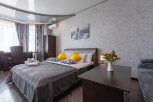 Habitación de hotel con cama y mesa en Уютные большие апартаменты RentPlaza возле парка en Samara