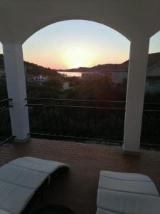 een patio met uitzicht op de zonsondergang en het water bij Apartman Ruza in Vela Luka