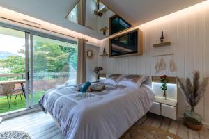 a bedroom with a large bed and a large window at LE QUINTESSENCE: Balnéo & Luminothérapie + parking in Voiron