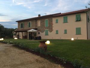 duży dom z zielonymi okiennicami i hydrantem przeciwpożarowym w obiekcie Agriturismo La Casina nel Vigneto w mieście Larciano