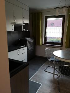 a small kitchen with a table and a window at Apartamenty Jaskinia Solna in Ruda Śląska