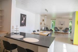 eine Küche und ein Wohnzimmer mit einem Tisch und Stühlen in der Unterkunft Le Moulin de Bosson - Une de Mai in Ferrières