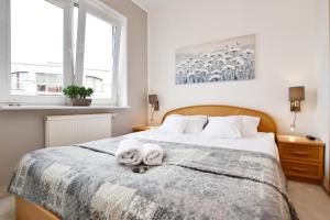 a bedroom with a bed with two towels on it at Apartament Porto in Kołobrzeg