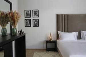 a bedroom with a bed and a table with pictures on the wall at Villa LOULA in Marrakesh +34 photos