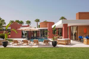 een resort met een zwembad en tafels en stoelen bij Villa LOULA in Marrakesh