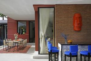een patio met blauwe stoelen en een tafel en een gebouw bij Villa LOULA in Marrakesh
