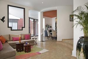 a living room with a couch and a dining room at Villa LOULA in Marrakesh