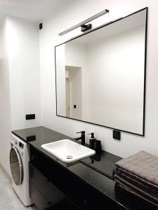a bathroom with a sink and a mirror at Luxurious 68m2 2BR 3-Room River View Apt in the heart of Pärnu in Pärnu