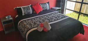 a bedroom with a bed with two stuffed animals on it at De Vine Martinborough 14 Cologne Street in Martinborough 