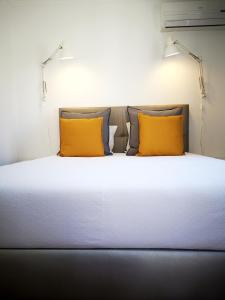 a bed with a white comforter and two pillows at The Bulldog Inn - Duna Parque Group in Vila Nova de Milfontes