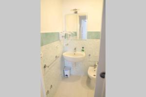 a white bathroom with a sink and a toilet at Casa Maadry in Ischia +35 photos