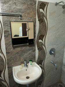 een badkamer met een wastafel en een spiegel bij Hotel Relax Inn in Nagpur