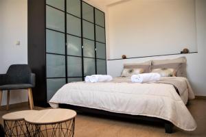 a bedroom with a bed with two towels on it at Grey Haven Luxury Villa in Stérnai +53 photos