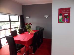 ein Esszimmer mit einem roten Tisch und schwarzen Stühlen in der Unterkunft De Vine Martinborough 14 Cologne Street in Martinborough 