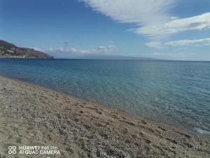 una spiaggia rocciosa con l'oceano sullo sfondo di Recanati taormina beach a Giardini Naxos