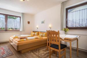 a bedroom with a bed and a table and a desk at Bett und Frühstück bei Gertrud in Hergensweiler