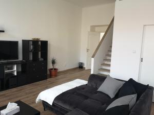 Fine apartment in centrum of Slaný with Aircondition في سلاني: غرفة معيشة مع أريكة وتلفزيون