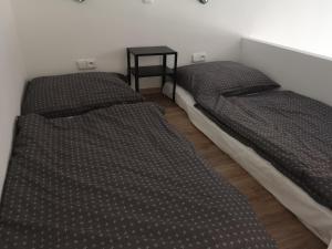 Fine apartment in centrum of Slaný with Aircondition في سلاني: سريرين في غرفة مع طاولة جانبية
