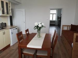 Fine apartment in centrum of Slaný with Aircondition في سلاني: طاولة غرفة الطعام مع إناء من الزهور عليها
